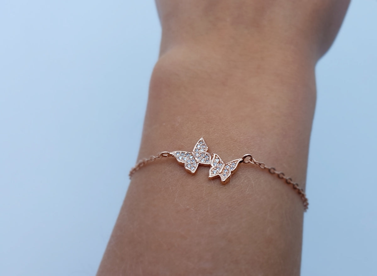 Damenarmband in Gold mit Schmetterling am Handgelenk getragen