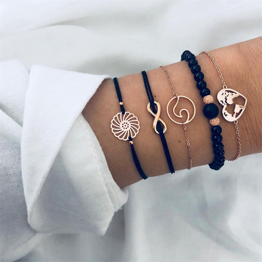 5-teiliges Damen Armband Set in Schwarz und Gold mit Unendlichkeitssymbol und dekorativen Anhängern