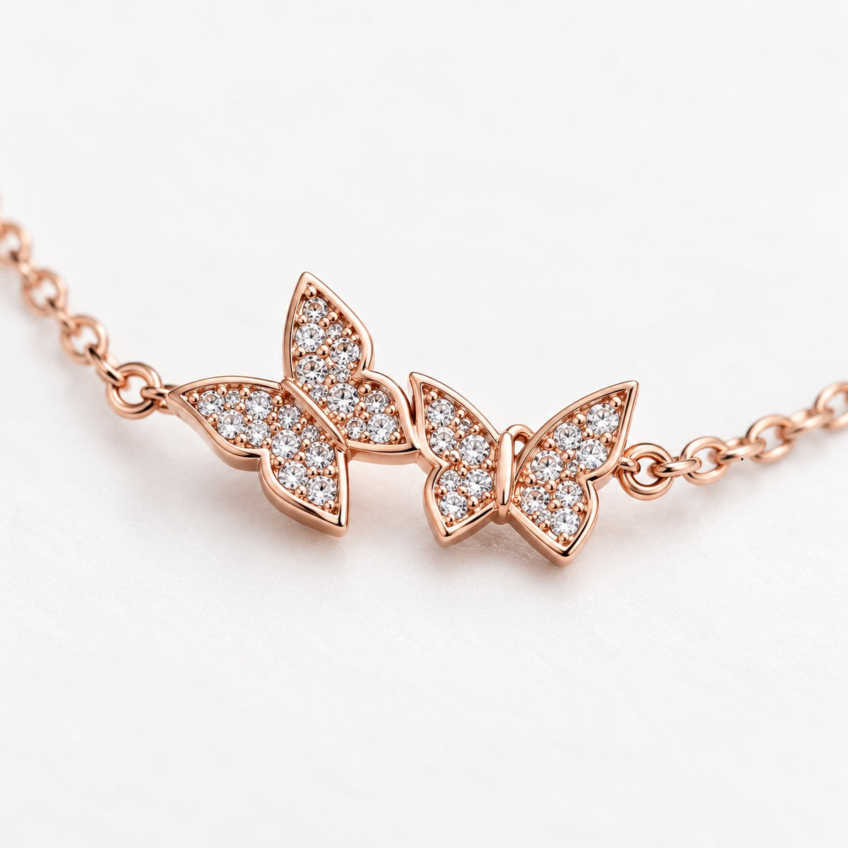 Detailaufnahme eines roségoldenen Schmetterling Armbands mit funkelnden Schmucksteinen