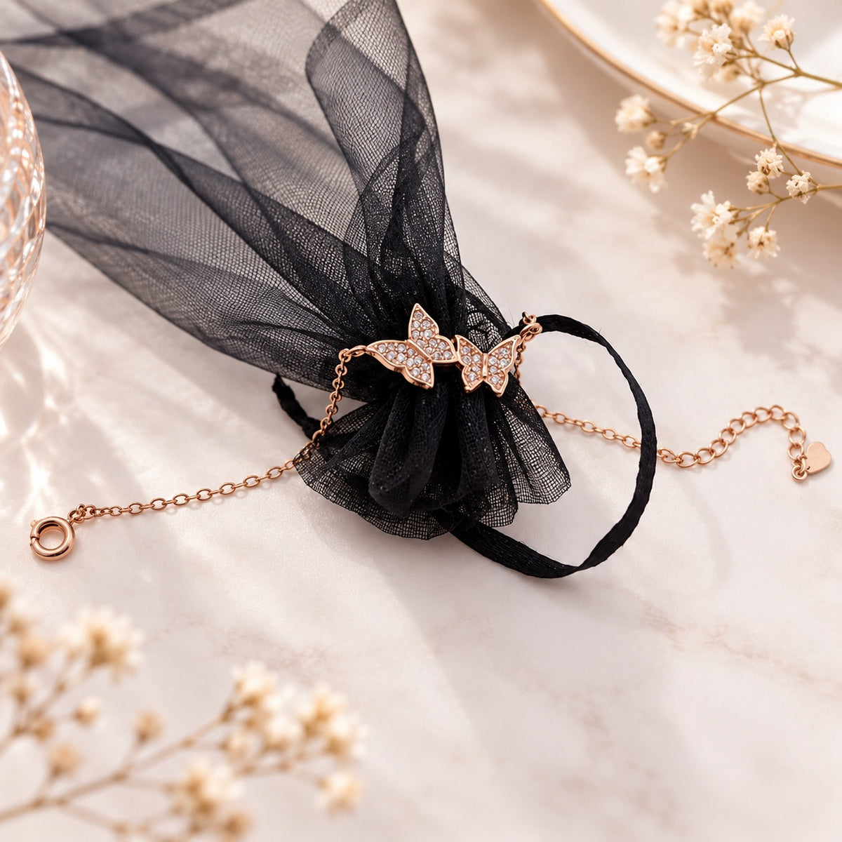 Roségoldenes Schmetterling Armband mit Schmucksteinen dekorativ mit schwarzem Schmuckbeutel präsentiert