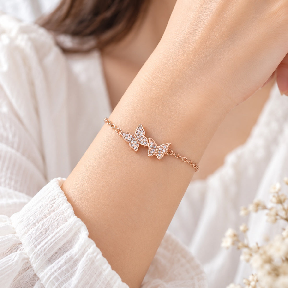Roségoldenes Schmetterling Armband mit funkelnden Steinen am Handgelenk getragen