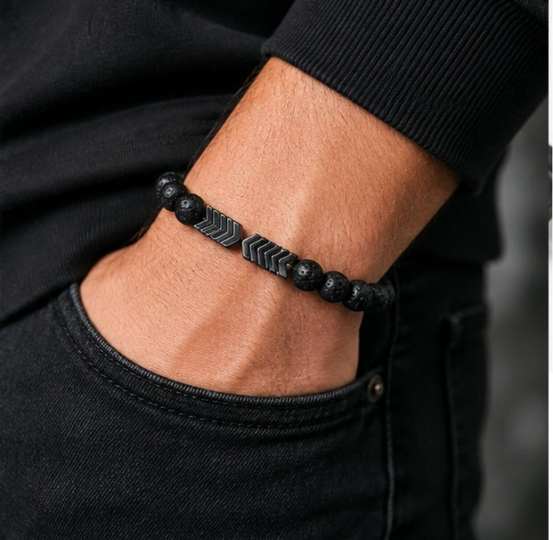 Schwarzes Lavastein Armband mit Pfeil-Design am Handgelenk getragen