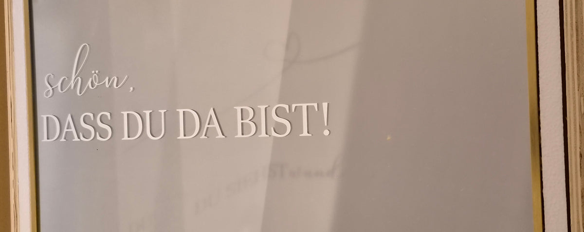 Weißer Schriftzug Schön dass du da bist auf goldenem Spiegel für Hochzeit und Event